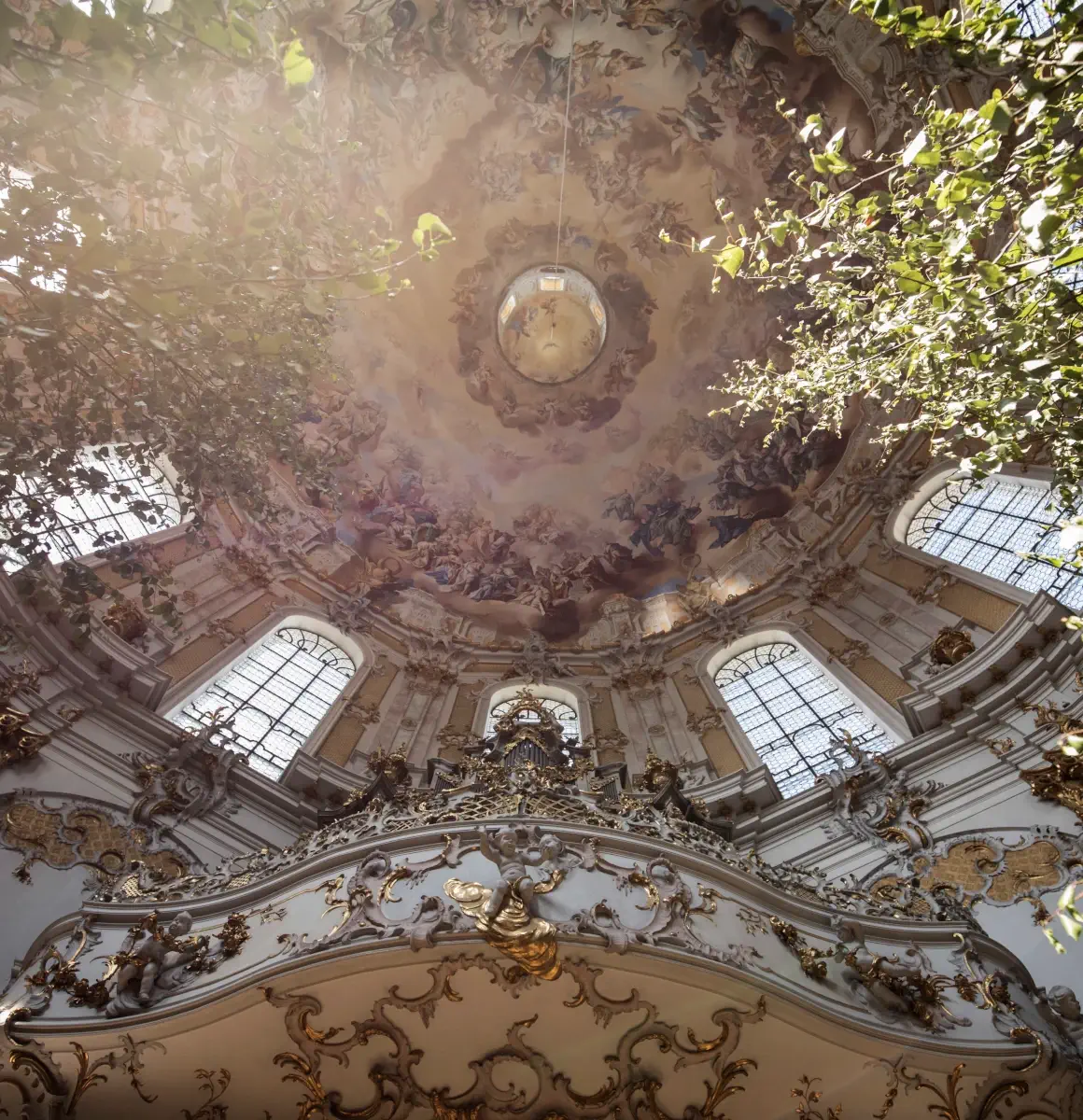Das Kloster und die Spiritualität im Kloster Ettal Die Decke der Basilika im Kloster Ettal von unten fotografiert, in Sonnenstrahlen getaucht